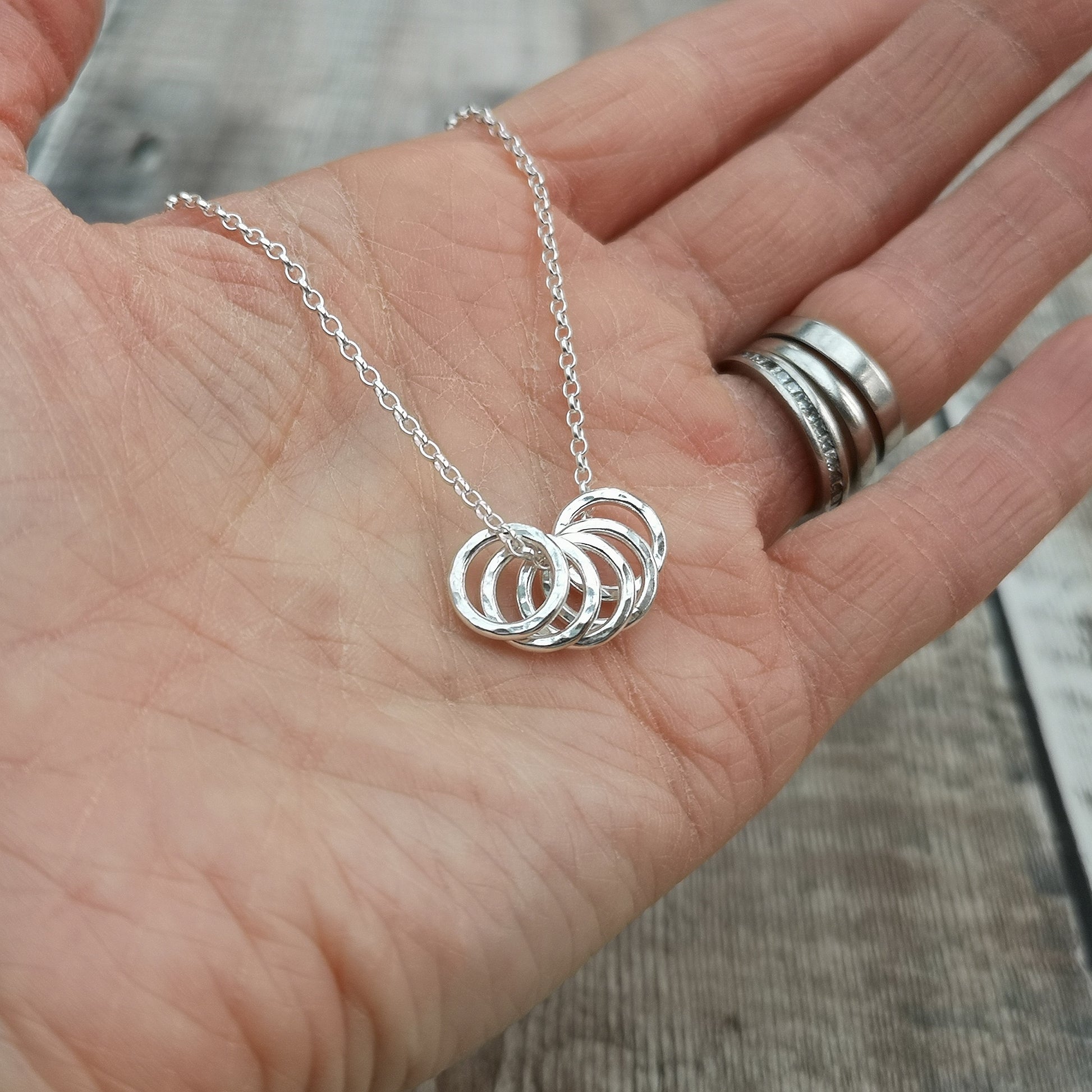 Five small Sterling Silver open circles with hammered texture finish on a silver chain.