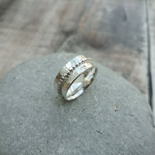 Approx. 8mm wide hammered texture silver band with additional 2mm wide silver beaded band around the middle that spins independently.