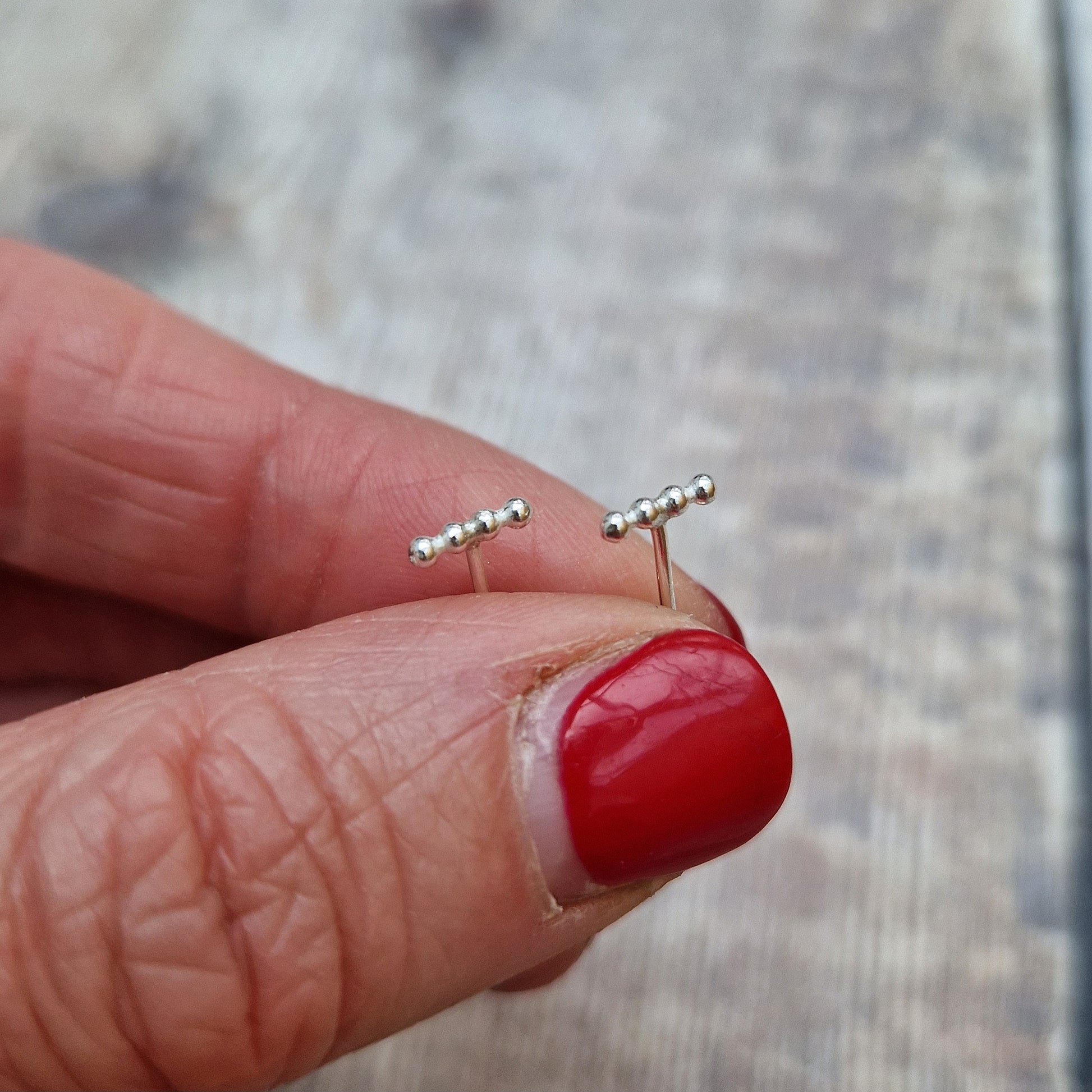 Each earring is four small Sterling Silver beads in a straight row attached to a silver stud bar.