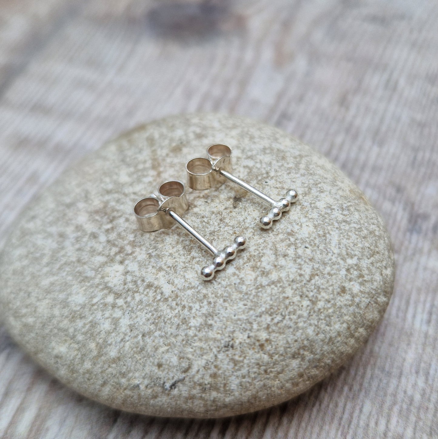 Each earring is four small Sterling Silver beads in a straight row attached to a silver stud bar.