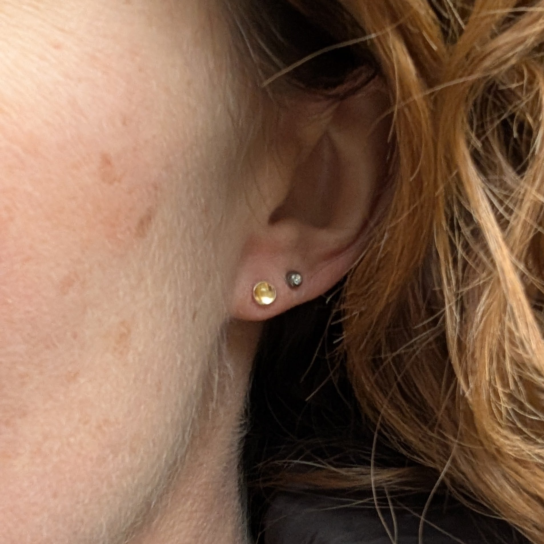 A woman wearing the citrine stud earrings, highlighting their size and radiant colour.