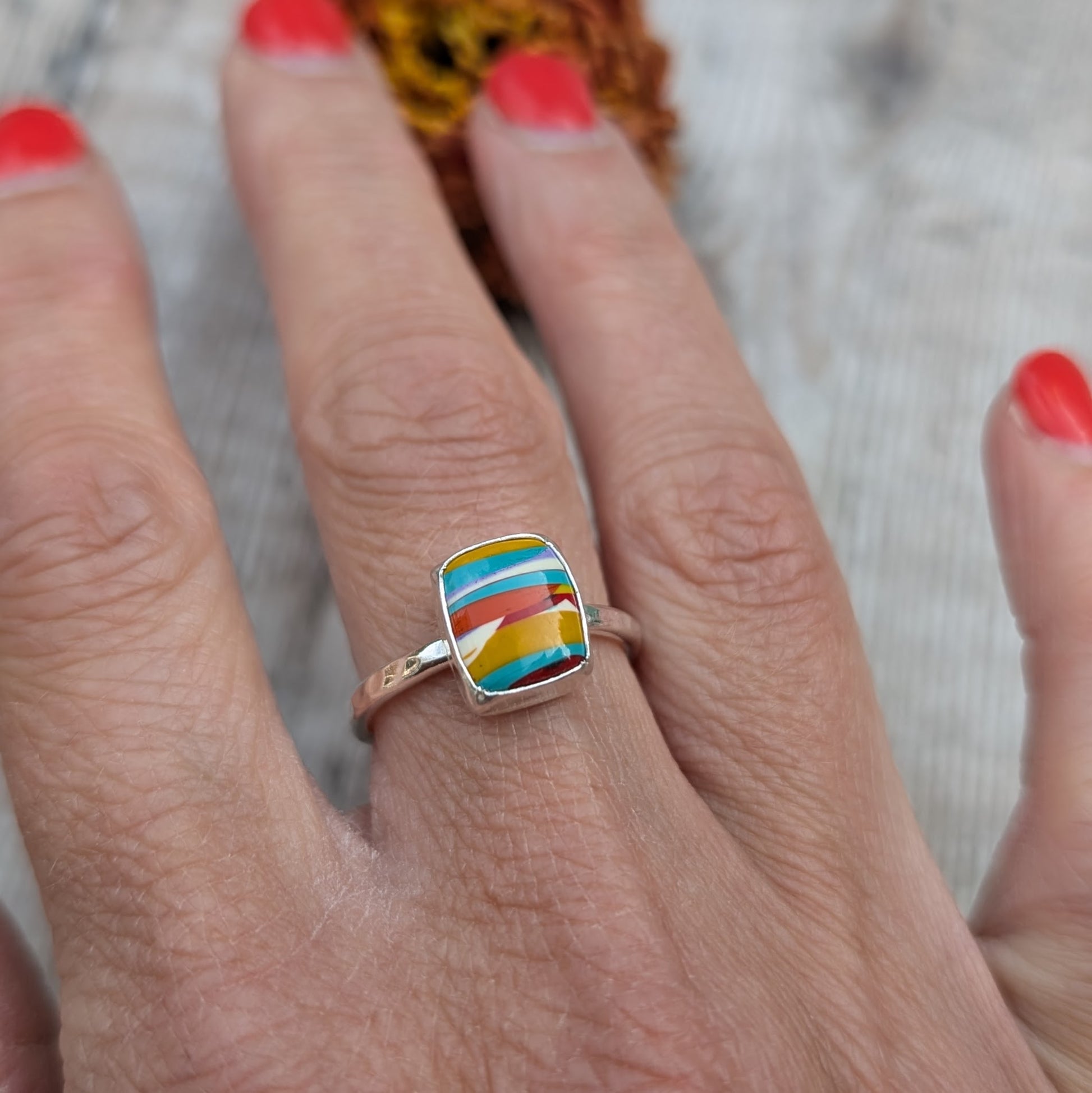 Colourful Surfite ring worn on hand, showing the vibrant stripes of the stone.