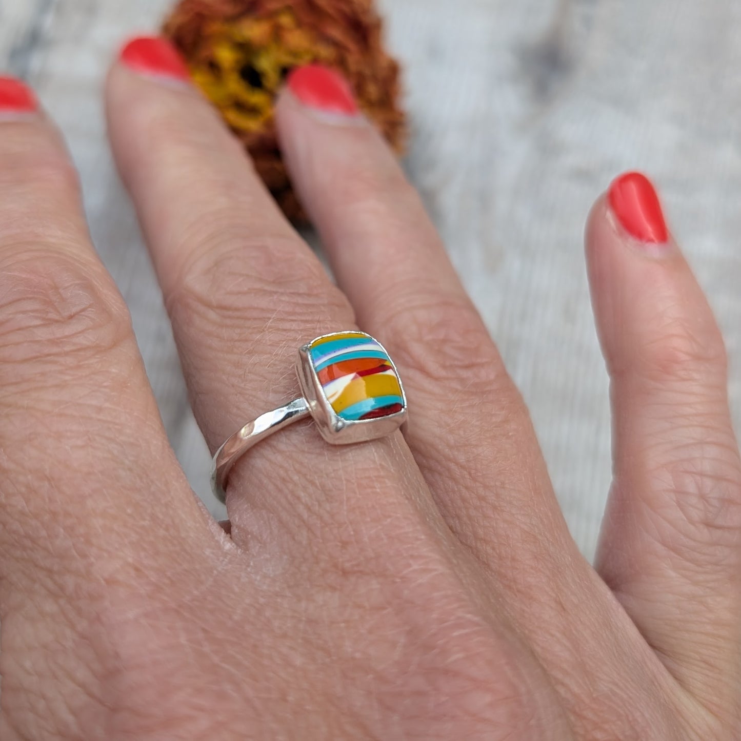 Colourful Surfite ring worn on hand, showing the vibrant stripes of the stone.