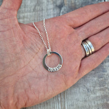 Load image into Gallery viewer, Sterling Silver ‘COURAGE’ necklace. Silver disc with offset hole in centre, looks like a thick circle. Attached via two small silver hoops to silver chain. On thicker part of disc, inscription wording hammered into the silver reads COURAGE in capitals. Disc measures approximately 20 mm in diameter. 