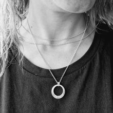 Load image into Gallery viewer, Sterling Silver ‘COURAGE’ necklace. Silver disc with offset hole in centre, looks like a thick circle. Attached via two small silver hoops to silver chain. On thicker part of disc, inscription wording hammered into the silver reads COURAGE in capitals. Disc measures approximately 20 mm in diameter. 