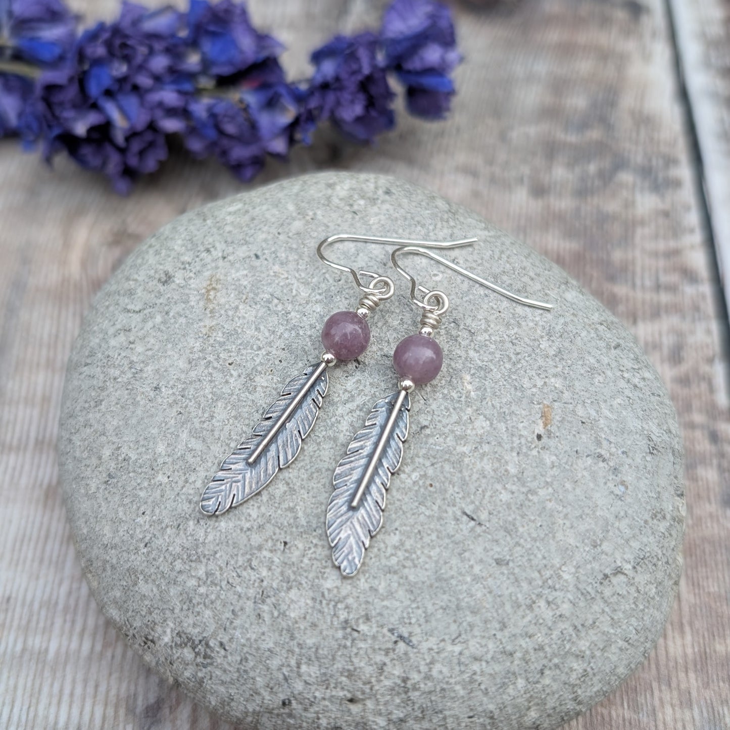 Recycled Sterling Silver Oxidised Feather Drop Earrings with Lavender Amethyst
Handmade from recycled sterling silver, these feather drop earrings feature detailed silver feathers paired with soft, lavender amethyst gemstones. The oxidised finish enhances the fine details of the feathers, adding depth and contrast to their intricate texture. The lavender amethyst beads bring a calming touch of natural colour, complementing the organic feel of the design. Suspended from handmade sterling silver ear wires, t