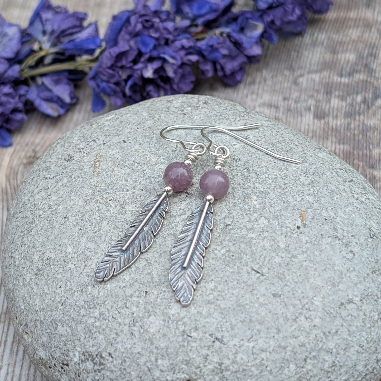 Recycled Sterling Silver Oxidised Feather Drop Earrings with Lavender Amethyst
Handmade from recycled sterling silver, these feather drop earrings feature detailed silver feathers paired with soft, lavender amethyst gemstones. The oxidised finish enhances the fine details of the feathers, adding depth and contrast to their intricate texture. The lavender amethyst beads bring a calming touch of natural colour, complementing the organic feel of the design. Suspended from handmade sterling silver ear wires, t