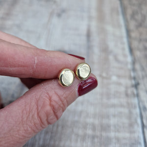 9ct gold pebble shape stud earrings. Recycled 9ct gold melted into a smooth, imperfect round pebble shape with small imperfections on the surface of the gold to provide subtle interest. Each pebble shape measuring approximately 8mm x 7mm, mounted on gold earring bar.