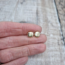 Load image into Gallery viewer, 9ct gold pebble shape stud earrings. Recycled 9ct gold melted into a smooth, imperfect round pebble shape with small imperfections on the surface of the gold to provide subtle interest. Each pebble shape measuring approximately 8mm x 7mm, mounted on gold earring bar.