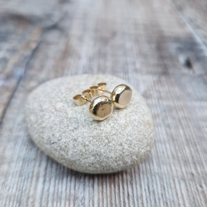 9ct gold pebble shape stud earrings. Recycled 9ct gold melted into a smooth, imperfect round pebble shape with small imperfections on the surface of the gold to provide subtle interest. Each pebble shape measuring approximately 8mm x 7mm, mounted on gold earring bar.