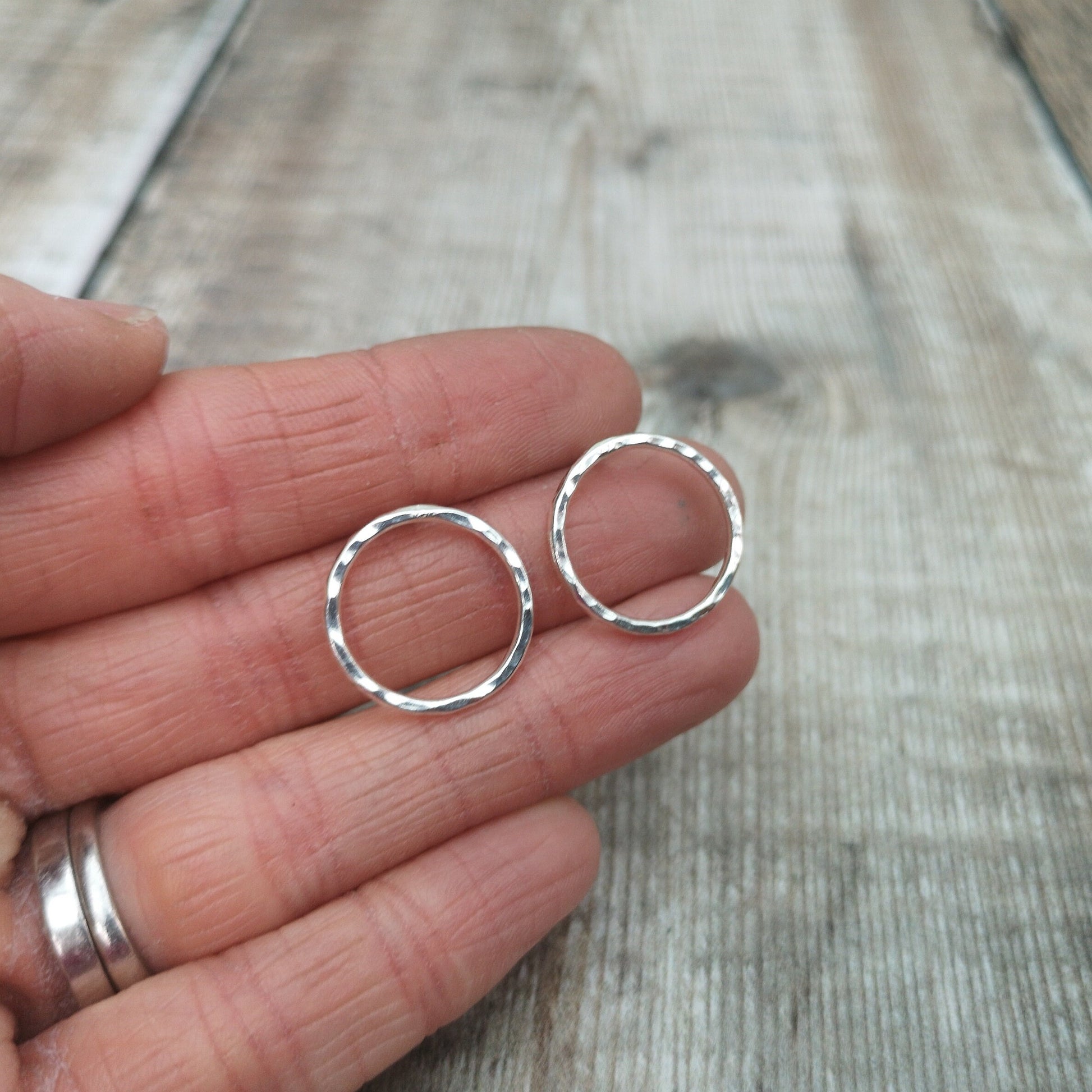 Each earring is a Sterling Silver open circle with hammered finish attached to a silver stud bar.