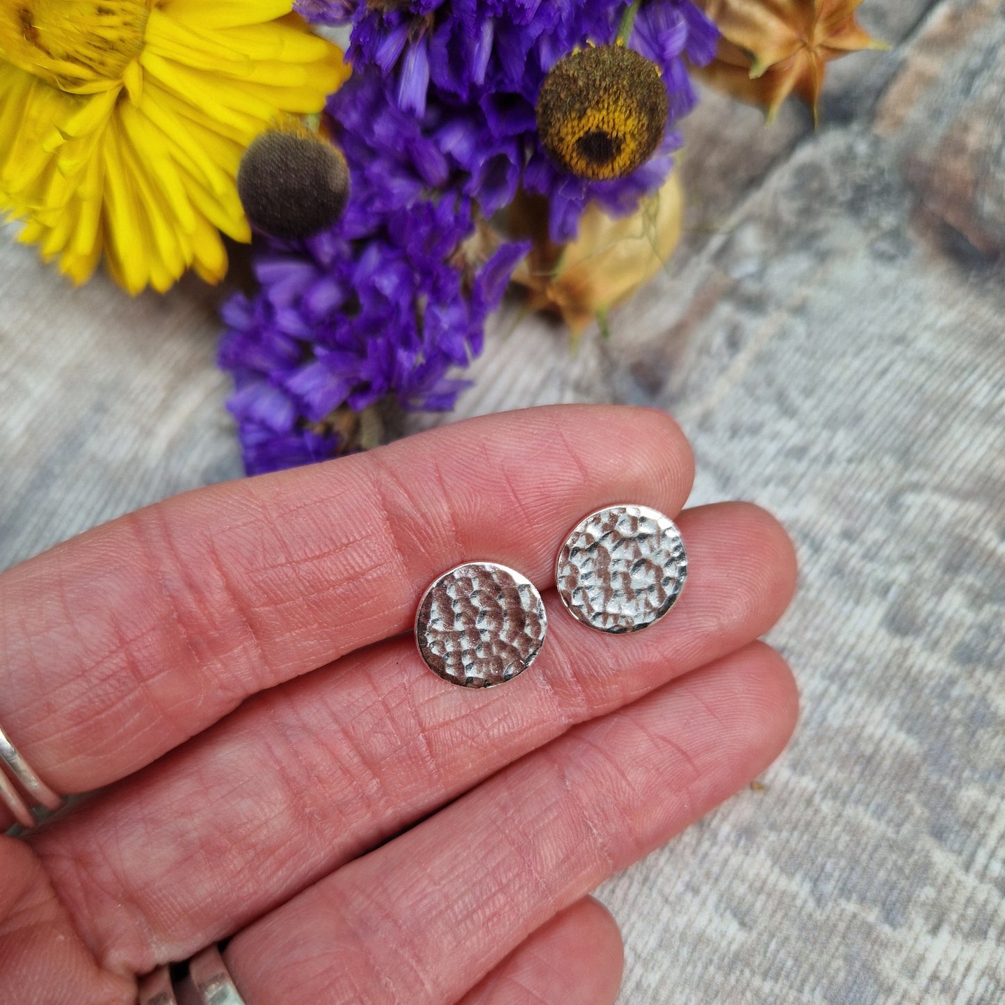 Each earring is a Sterling Silver flat disc with hammered texture mounted onto a stud bar.