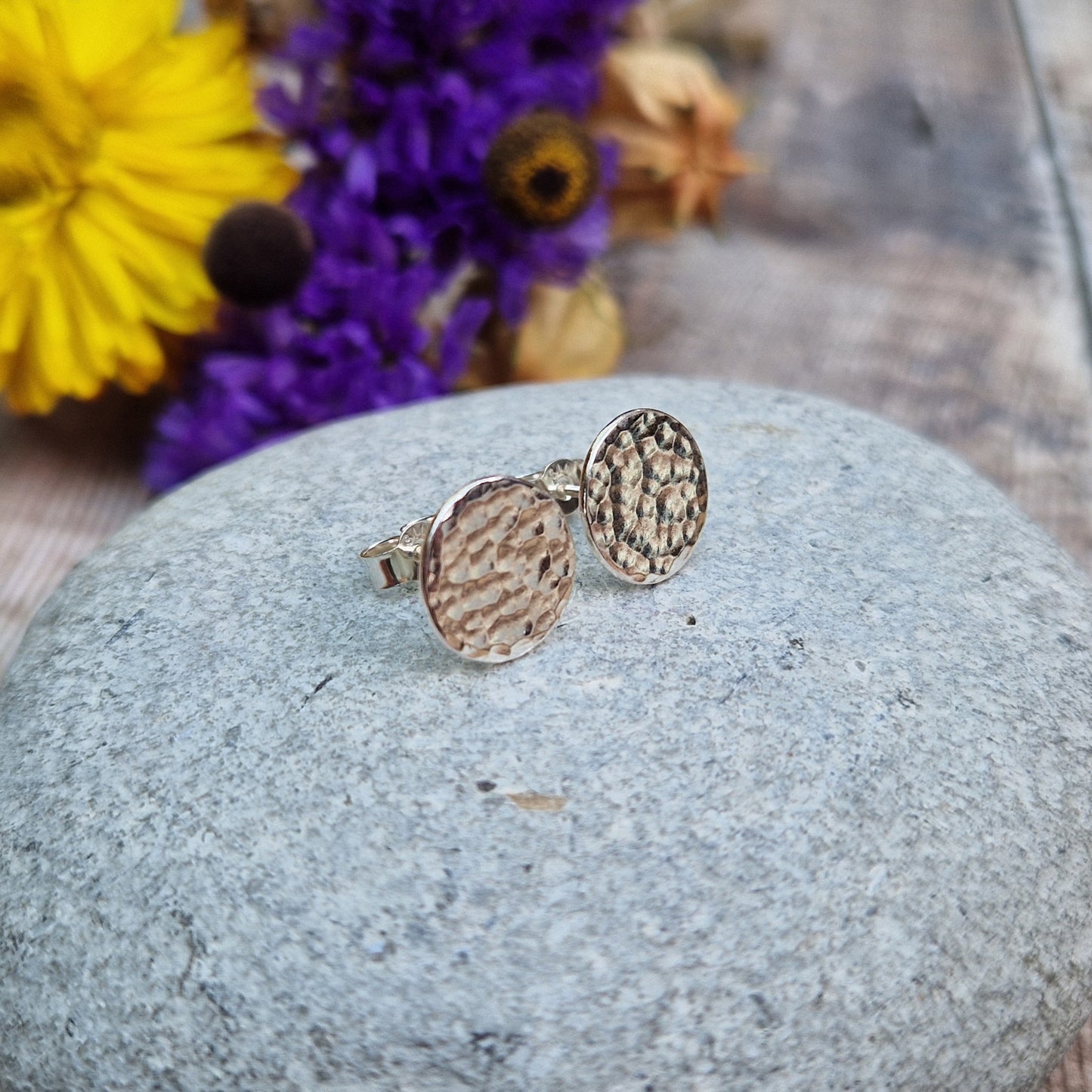 Each earring is a Sterling Silver flat disc with hammered texture mounted onto a stud bar.