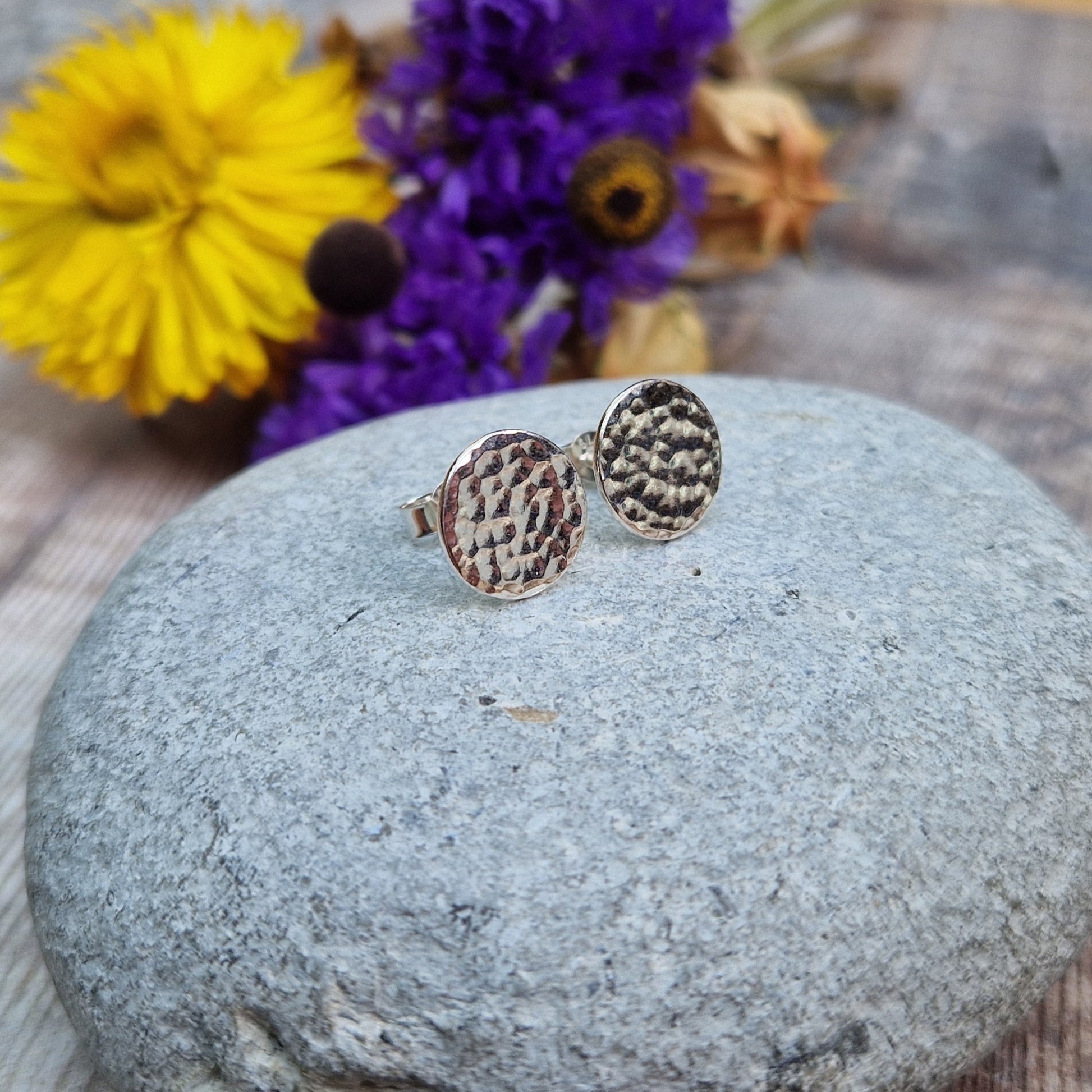 Each earring is a Sterling Silver flat disc with hammered texture mounted onto a stud bar.