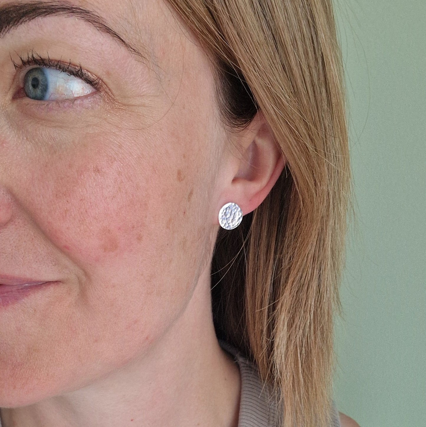 Each earring is a Sterling Silver flat disc with hammered texture mounted onto a stud bar.
