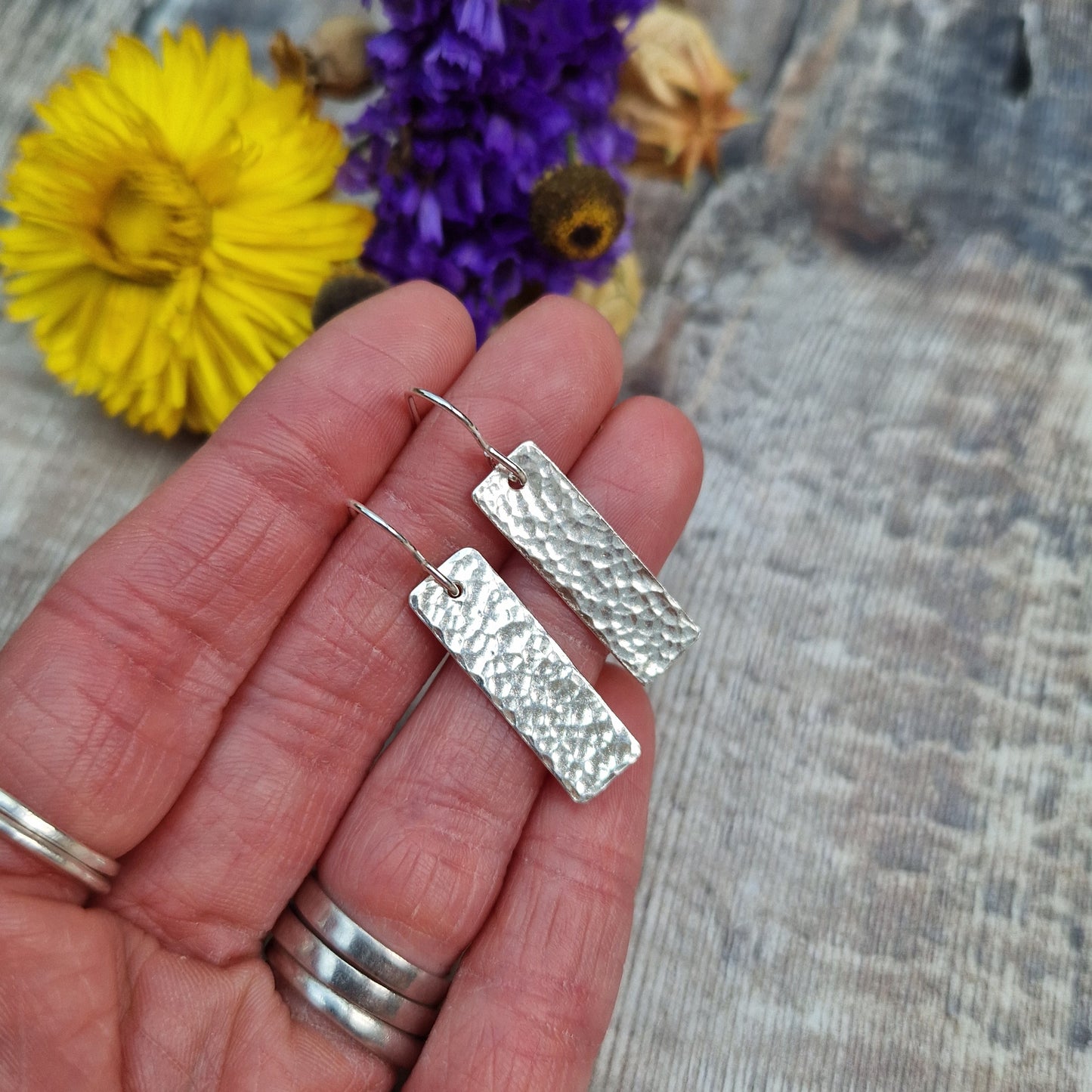 Each earring is a silver rectangle with hammered texture finish suspended from a silver earring wire.