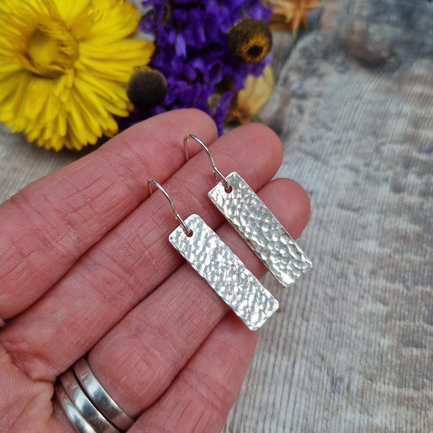 Each earring is a silver rectangle with hammered texture finish suspended from a silver earring wire.