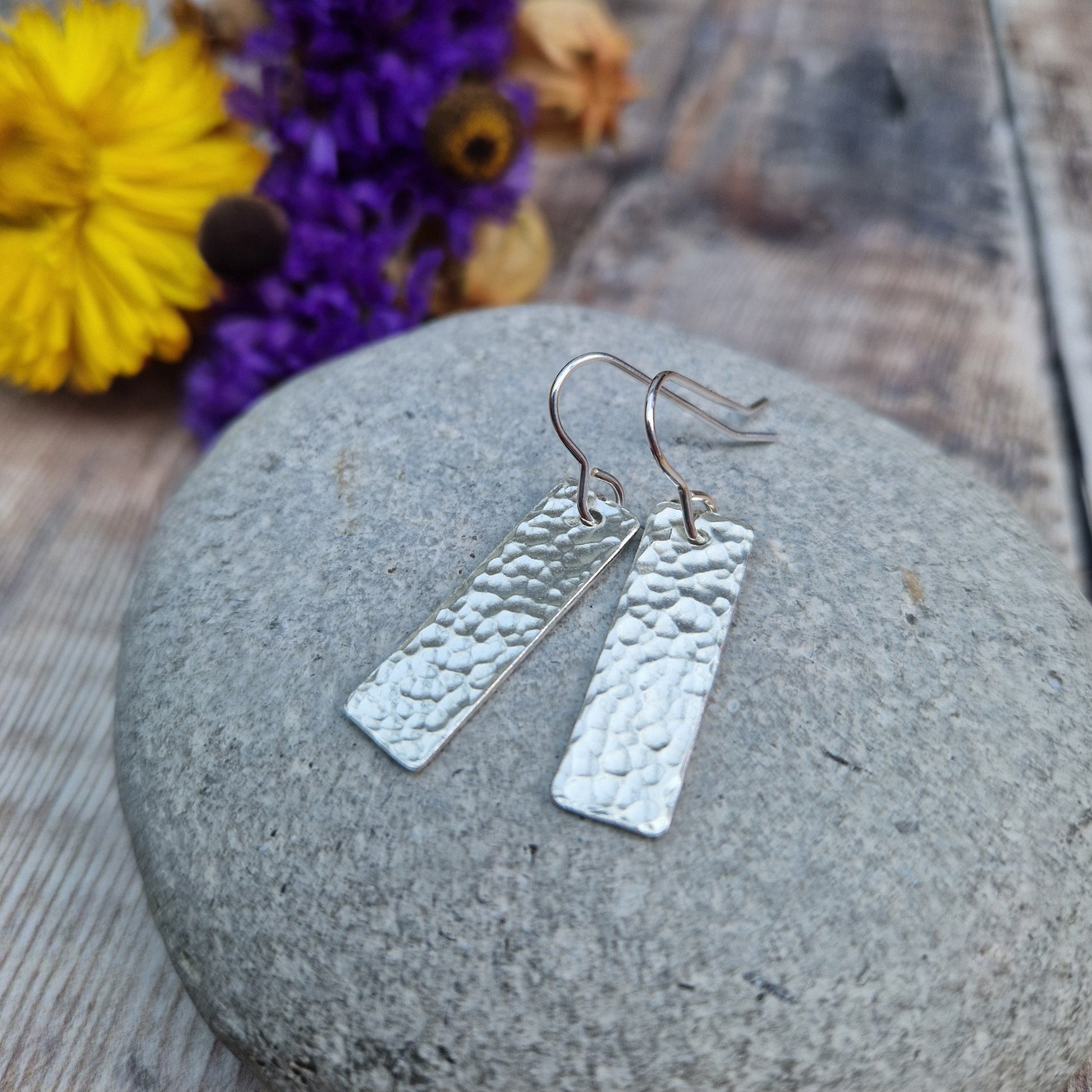 Each earring is a silver rectangle with hammered texture finish suspended from a silver earring wire.