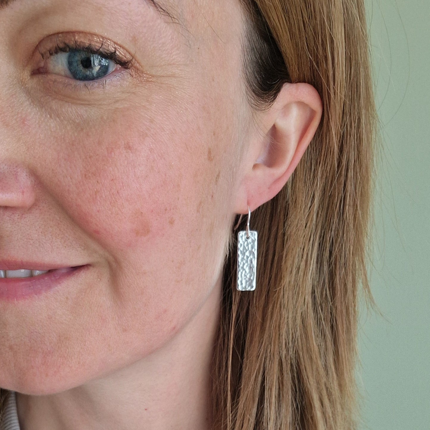 Each earring is a silver rectangle with hammered texture finish suspended from a silver earring wire.