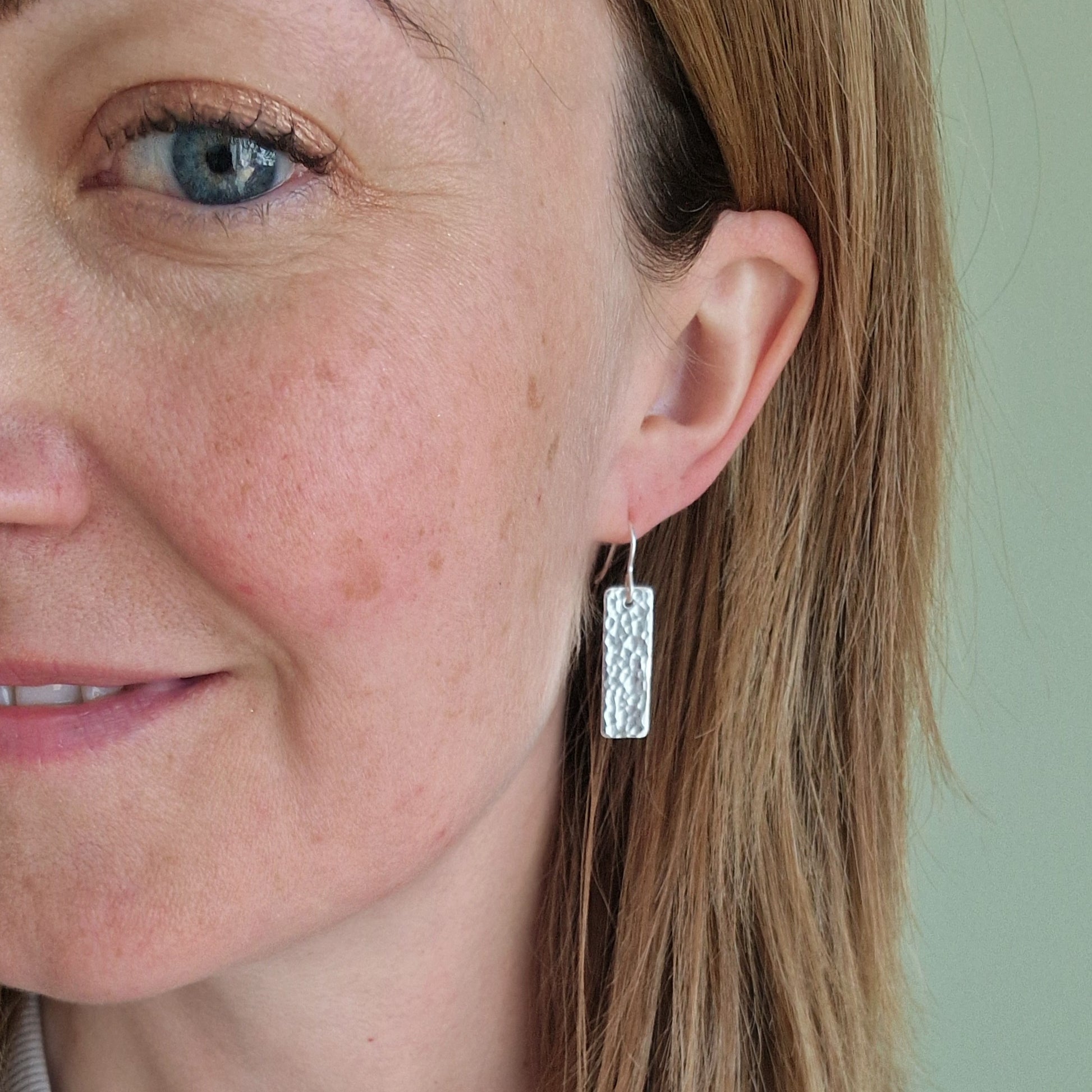 Each earring is a silver rectangle with hammered texture finish suspended from a silver earring wire.