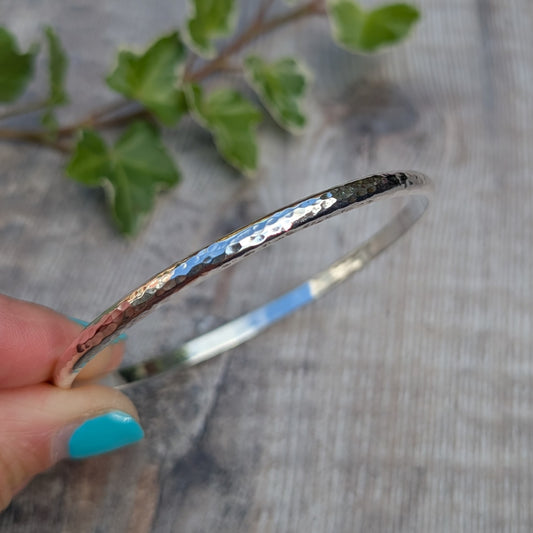 Side view of a Hammered Sterling Silver D Shape Bangle handmade from recycled Sterling Silver D shaped wire, showing the polished hammered finish.