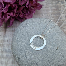 Load image into Gallery viewer, Sterling Silver ‘LOVE’ necklace. Silver disc with offset hole in centre, looks like a thick circle. Attached via two small silver hoops to silver chain. On thicker part of disc, inscription wording hammered into the silver reads LOVE in capitals. Disc measures approximately 20 mm in diameter. Chain length 18 inches.