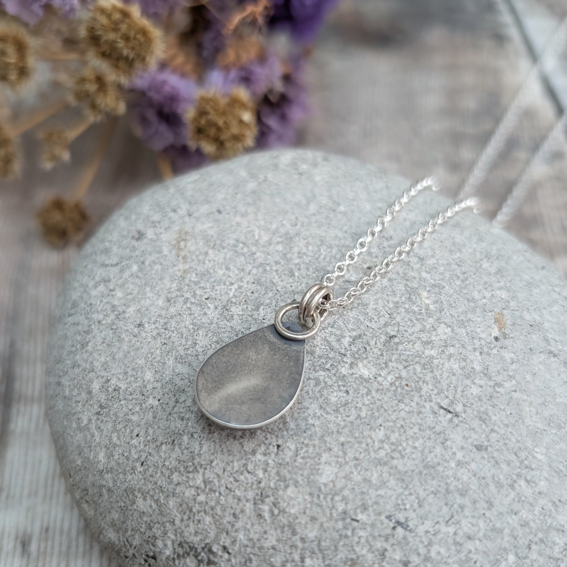 Back view of the Mohave Turquoise pendant
Rear view of a handmade sterling silver Mohave Turquoise necklace, showing the smooth, polished silver back and double ring bail. The oxidised silver frame adds depth, while the bright silver chain offers a clean, polished contrast.
