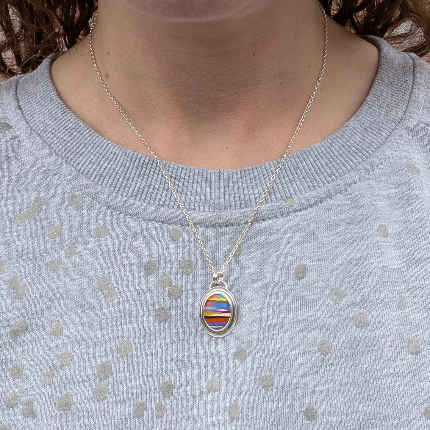 Surfite necklace worn around the neck, showing the 18-inch chain length and how the pendant sits when worn.