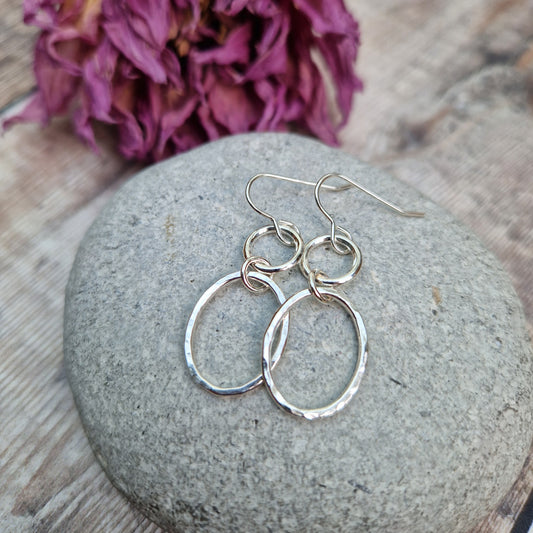 Each earring has one Sterling Silver open circle suspended from silver earring wire. A hammered texture silver open oval hangs from the open circle via a small circle link.