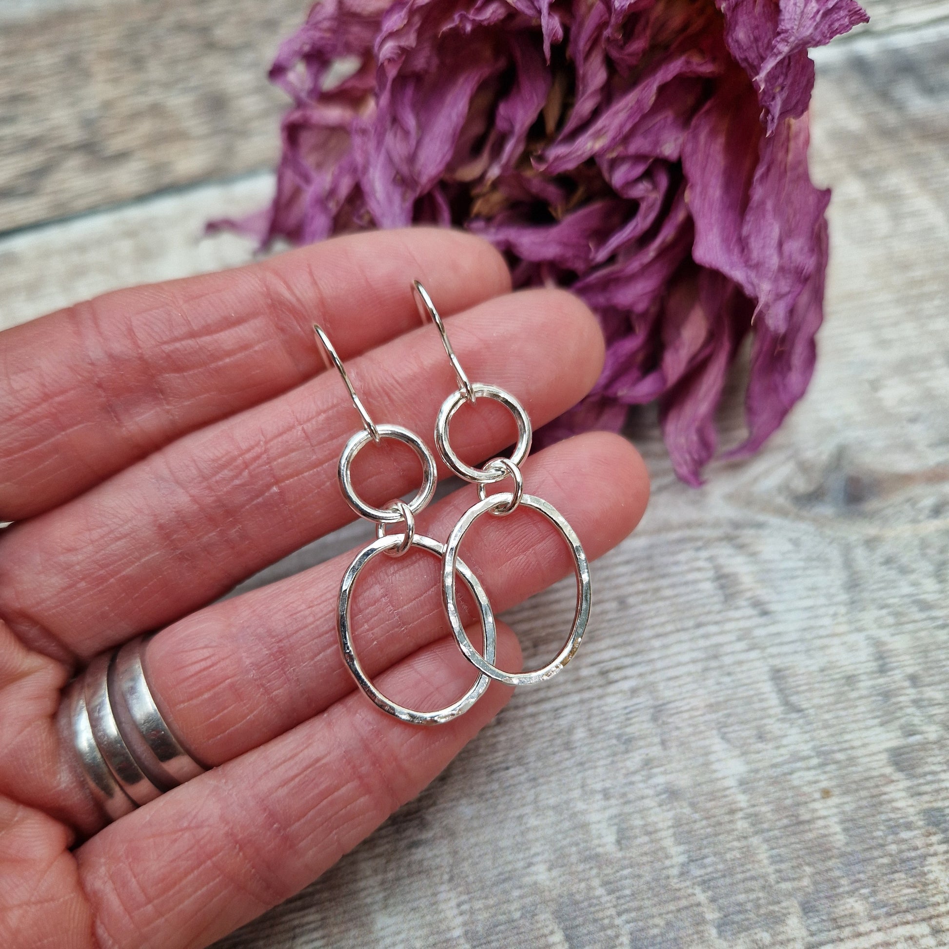 Each earring has one Sterling Silver open circle suspended from silver earring wire. A hammered texture silver open oval hangs from the open circle via a small circle link.