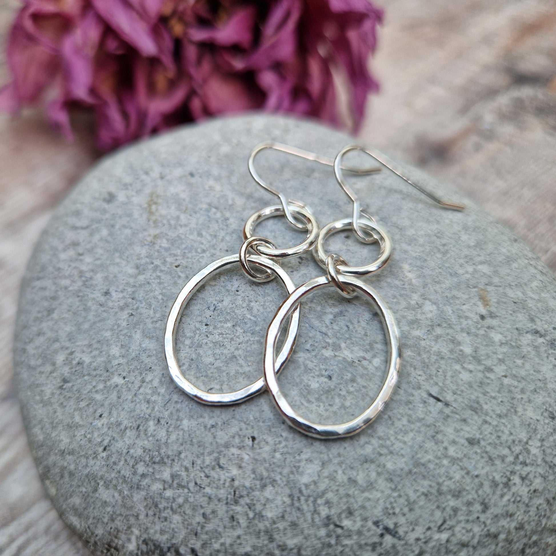 Each earring has one Sterling Silver open circle suspended from silver earring wire. A hammered texture silver open oval hangs from the open circle via a small circle link.