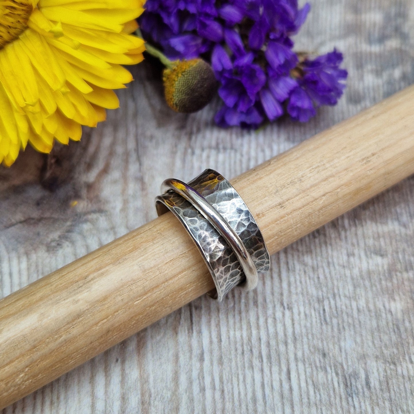 Wide oxidised Sterling Silver band with hammered texture finish with additional 2mm wide silver band around the middle that spins independently.