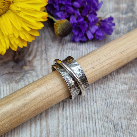 Wide oxidised Sterling Silver band with hammered texture finish with additional 2mm wide silver band around the middle that spins independently.