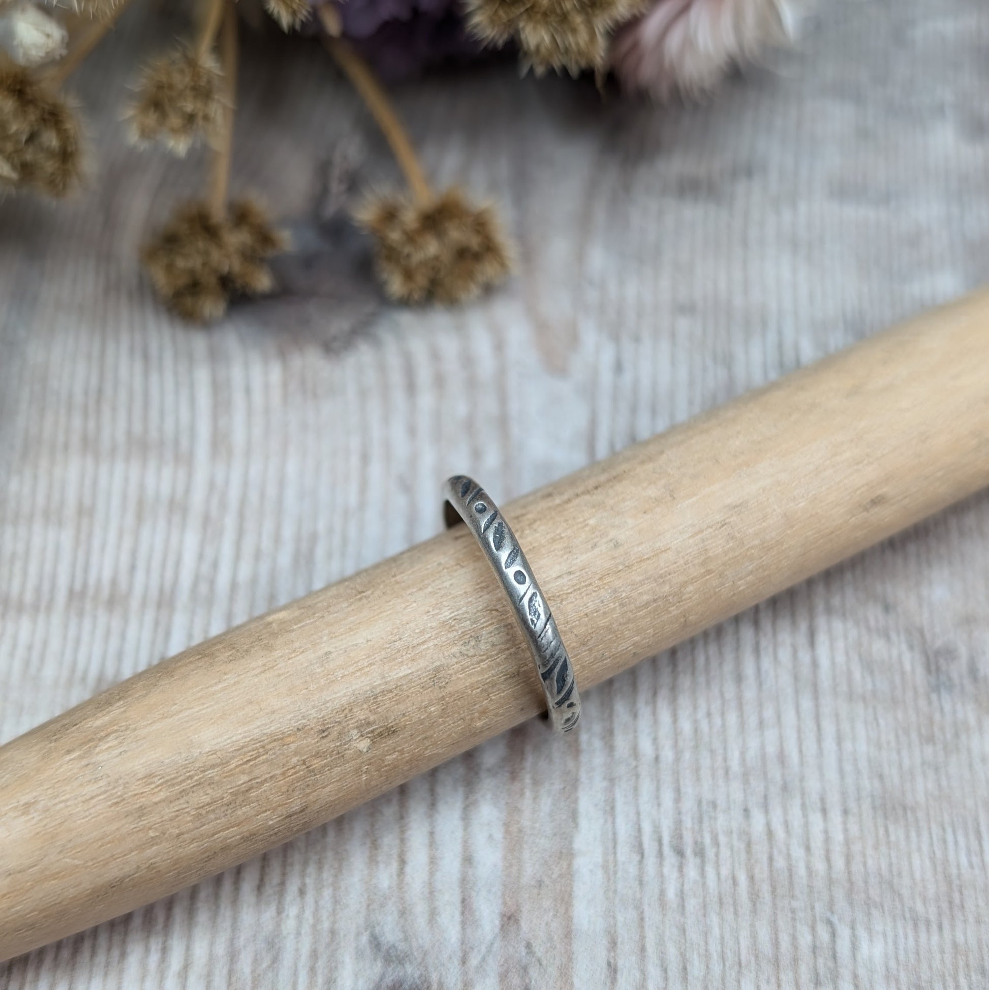 Oxidised Sterling silver band approx. 2mm diameter stamped with dot and leaf pattern.
