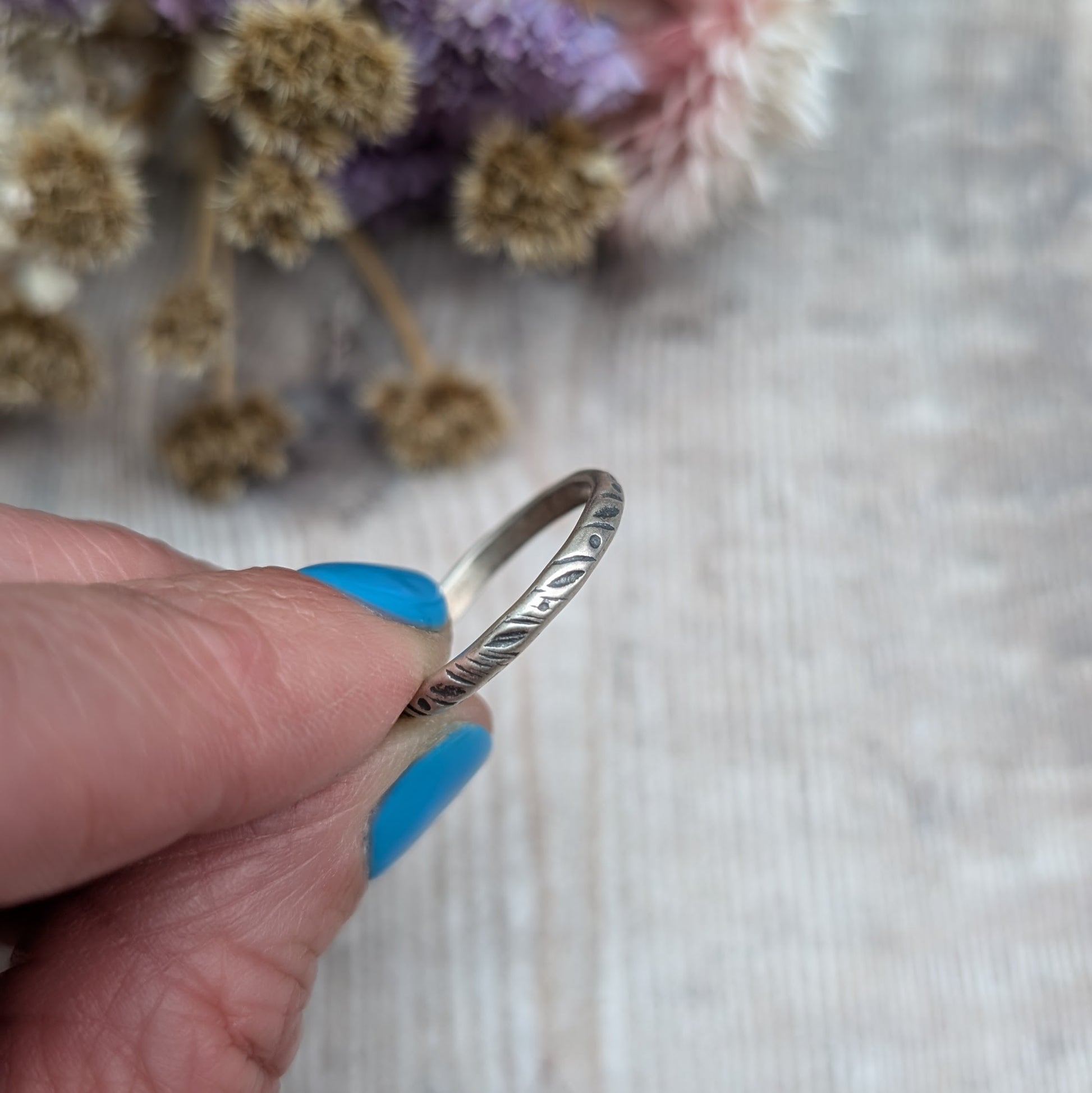 Oxidised Sterling silver band approx. 2mm diameter stamped with dot and leaf pattern.