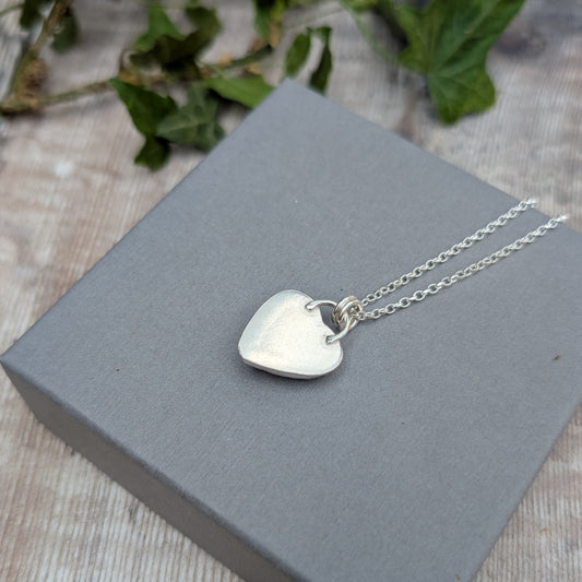 Back view of a Pink Aurora Opal Heart Necklace handmade from recycled Sterling Silver, showing the smooth silver back of the heart pendant.