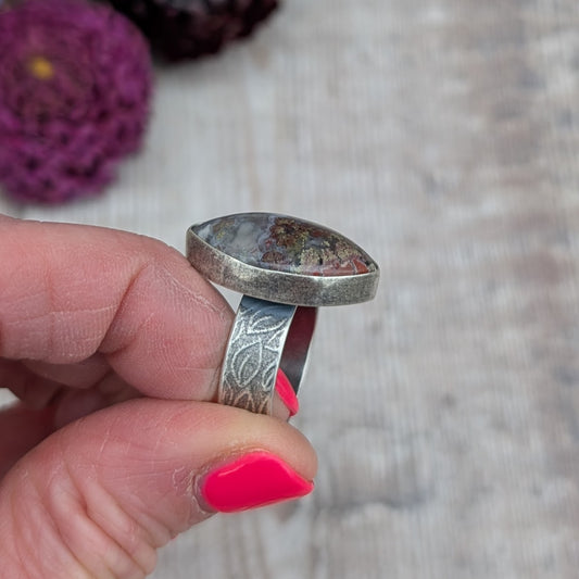 Side view of Silver Plume Agate Ring showing raised handmade setting and leaf pattern band in recycled sterling silver
