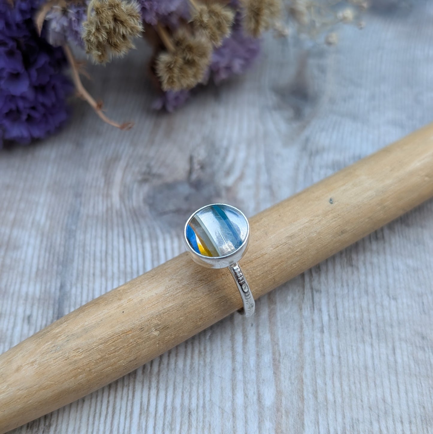 Round Surfite ring resting on a ring mandrel, with a clear view of the layered Surfite stone and silver band texture.