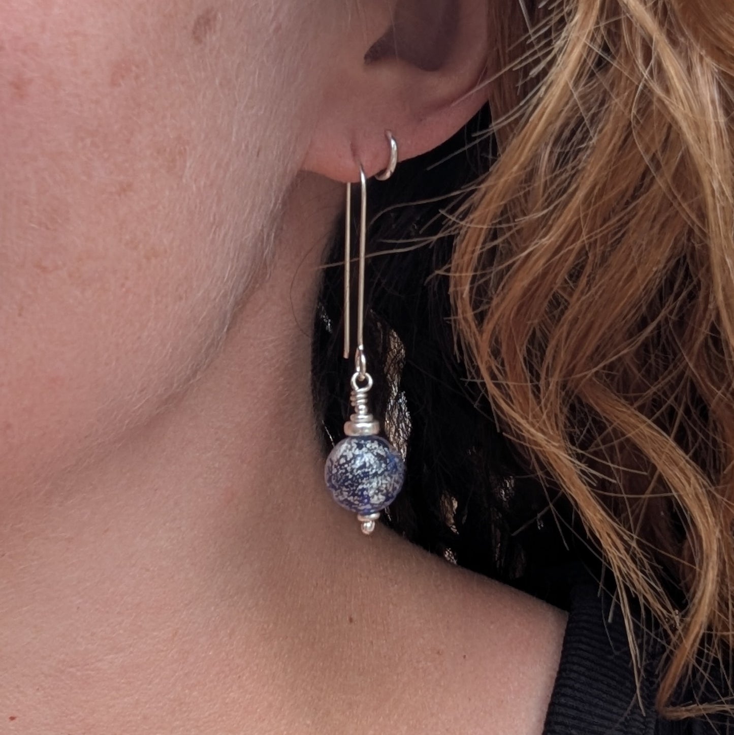 Silver blue venetian glass earrings shown being worn.