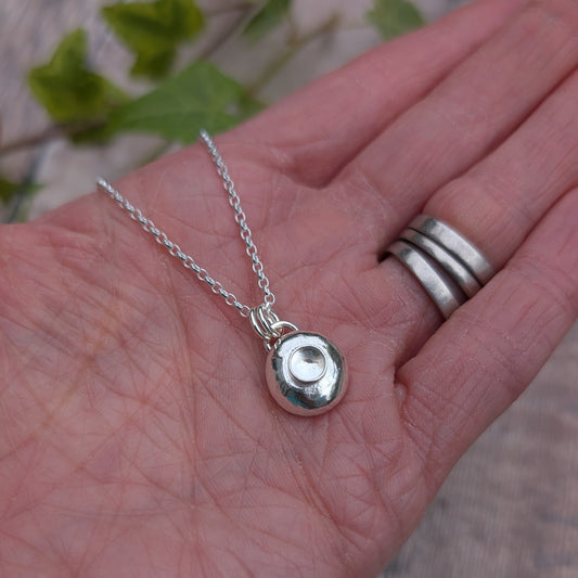 Silver Pebble Necklace with Crystal Quartz held in a hand showing size and scale