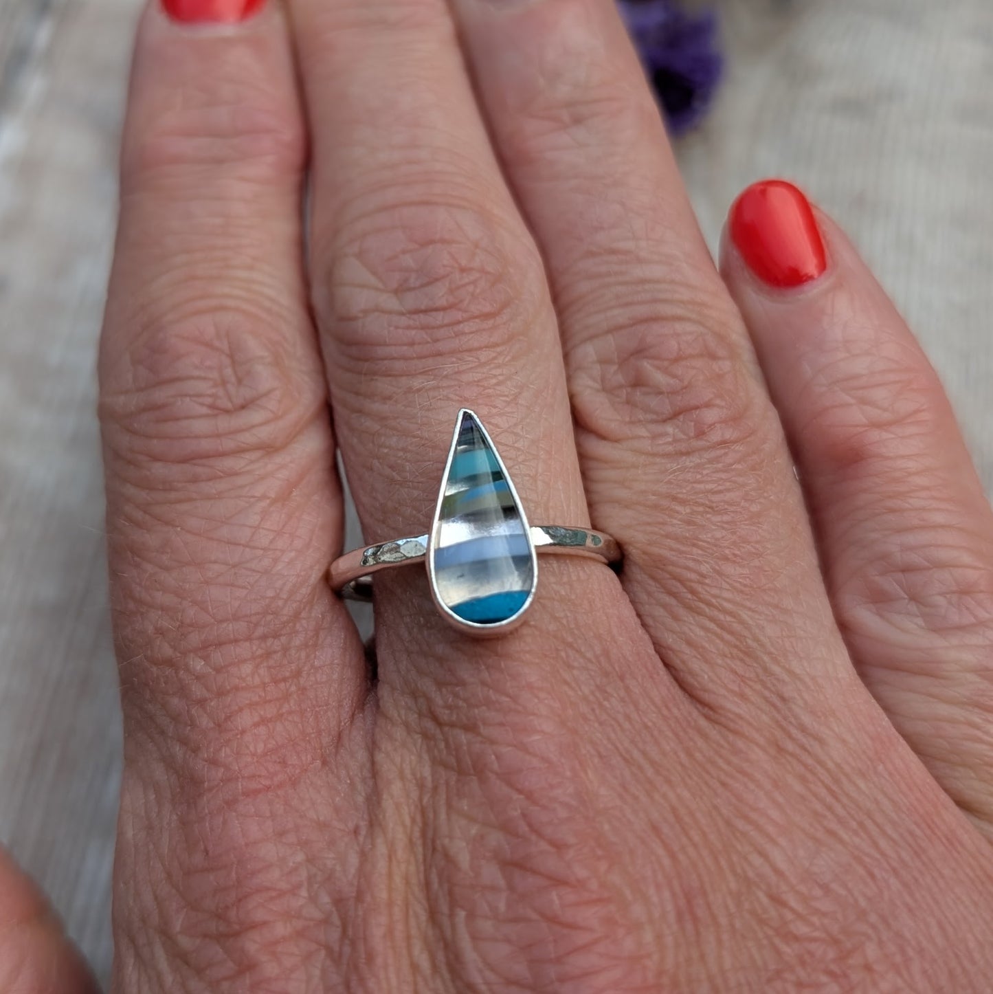 Recycled silver Surfite teardrop ring worn on hand, showing the size and hammered band detail.