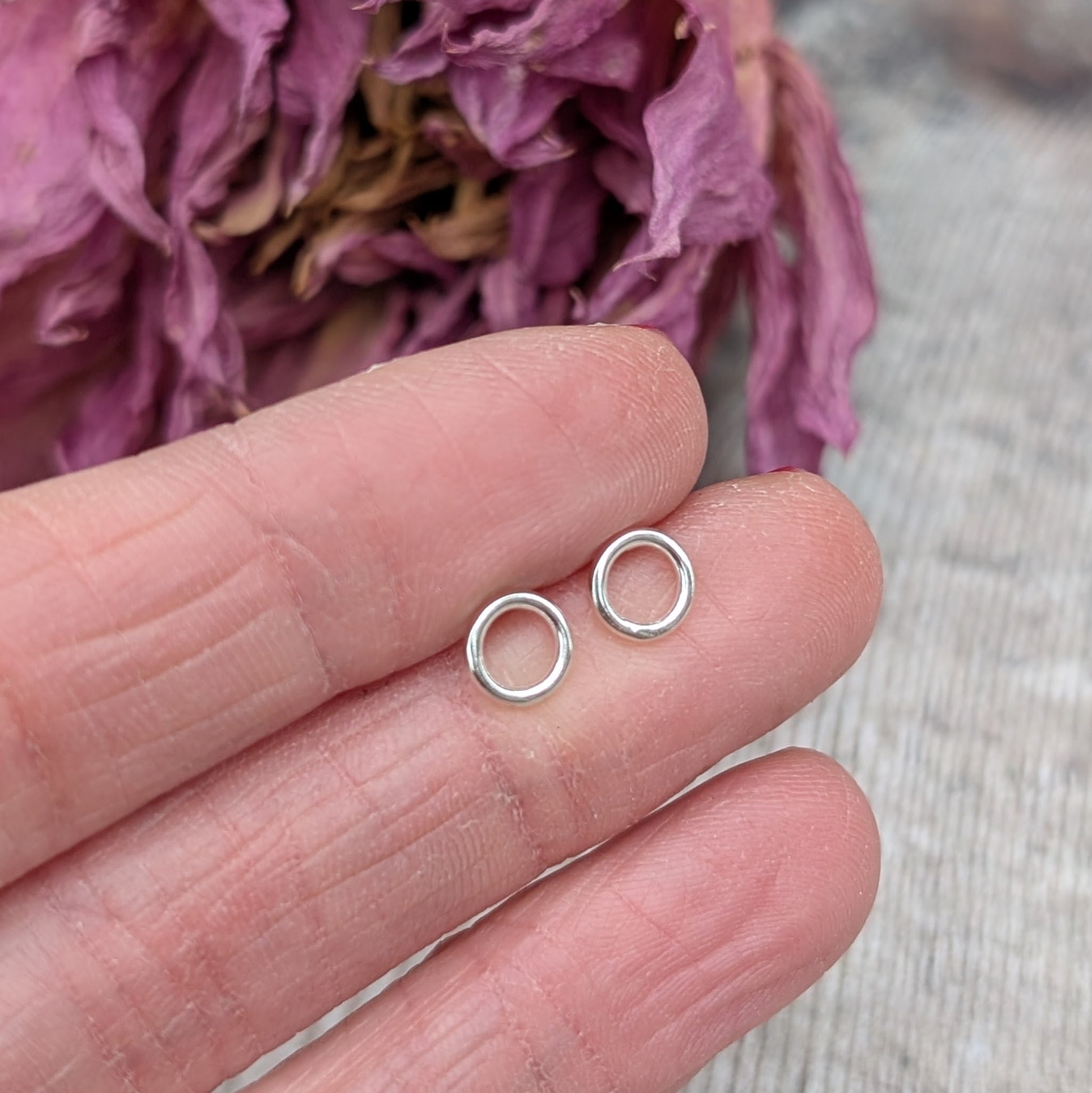 Each earring is a 6mm wide Sterling Silver smooth open circle attached to silver stud bar.