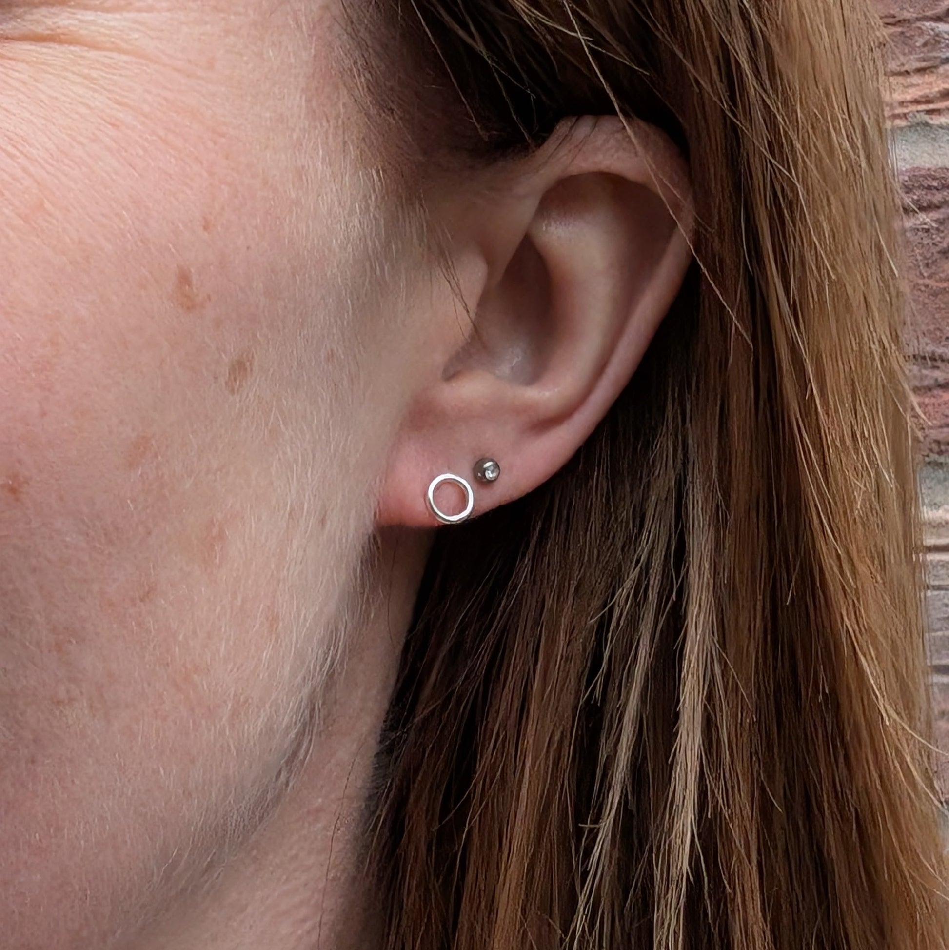Each earring is a 6mm wide Sterling Silver smooth open circle attached to silver stud bar.