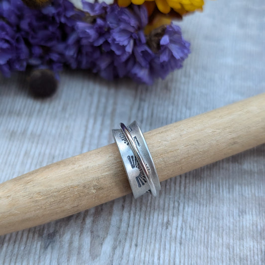 Wide oxidised Sterling Silver band with stamped sunrise pattern. Additional 2mm wide silver band around the middle that spins independently.