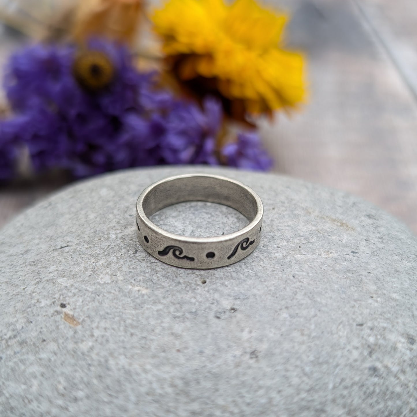 Sterling Silver ring, flat base with simple breaking wave and dot repeating pattern. Oxidisation makes the hand stamped pattern darker and visible.