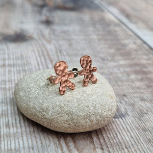 Copper gingerbread man shaped stud earrings set on sterling silver bars. Gingerbread man shape measures approximately 8mm x 12mm with hammered texture and two button indentations.
