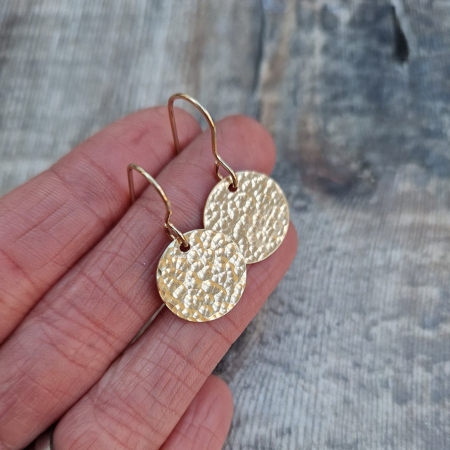 Gold hammered disc drop earrings. Each earring has one gold filled disc with hammered texture dropping from gold earring wire. Disc measuring approximately 15mm diameter.
