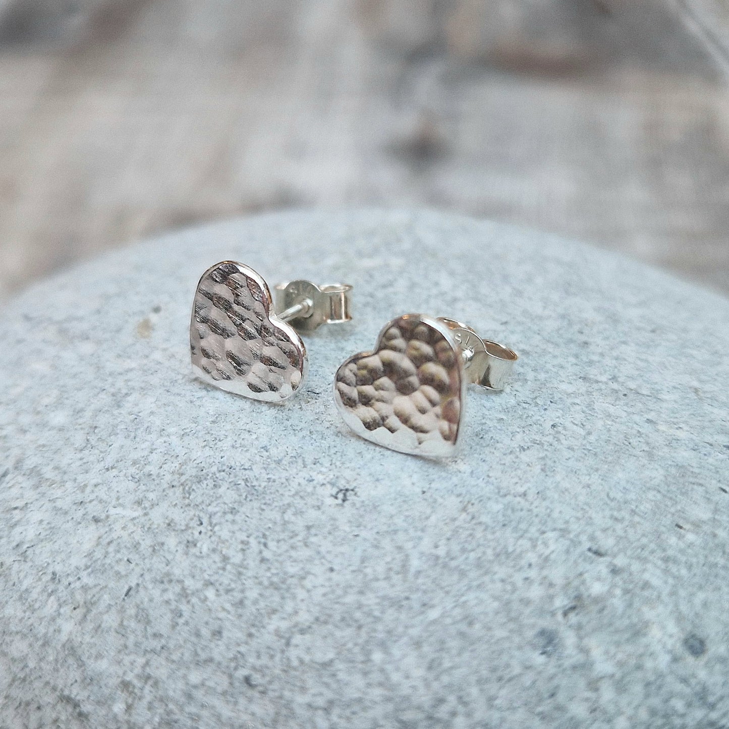Each earring is a Sterling Silver heart shape with hammered texture mounted on a stud bar.