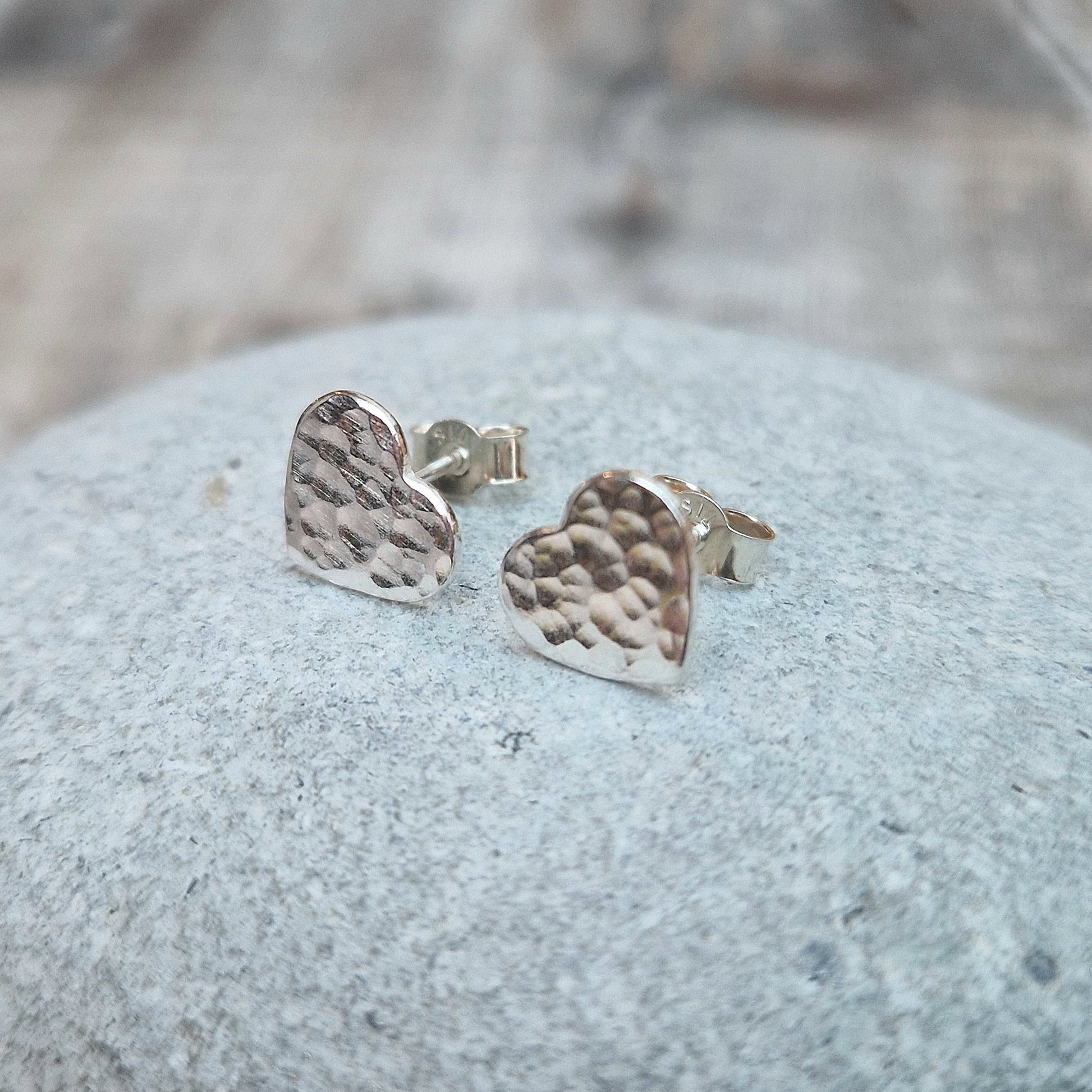 Each earring is a Sterling Silver heart shape with hammered texture mounted on a stud bar.