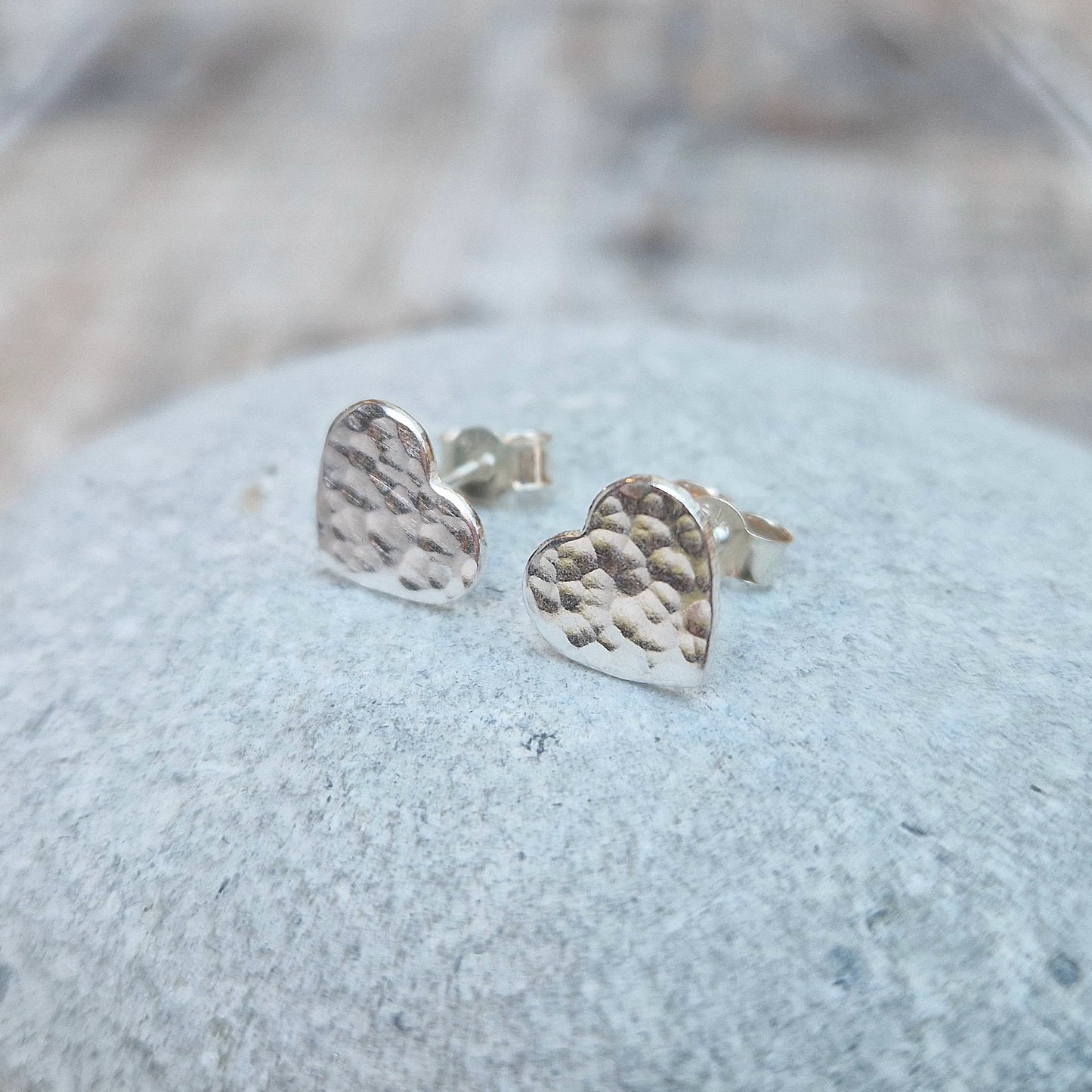 Each earring is a Sterling Silver heart shape with hammered texture mounted on a stud bar.